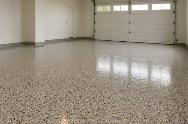 Custom flake floor design in a bright garage, featuring colorful texture and a smooth, glossy finish.